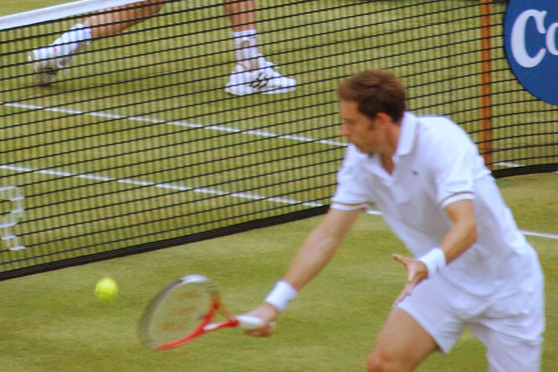 Andy Murray i Nicolas Mahut podczas gry przy siatce na trawie w 2013 roku