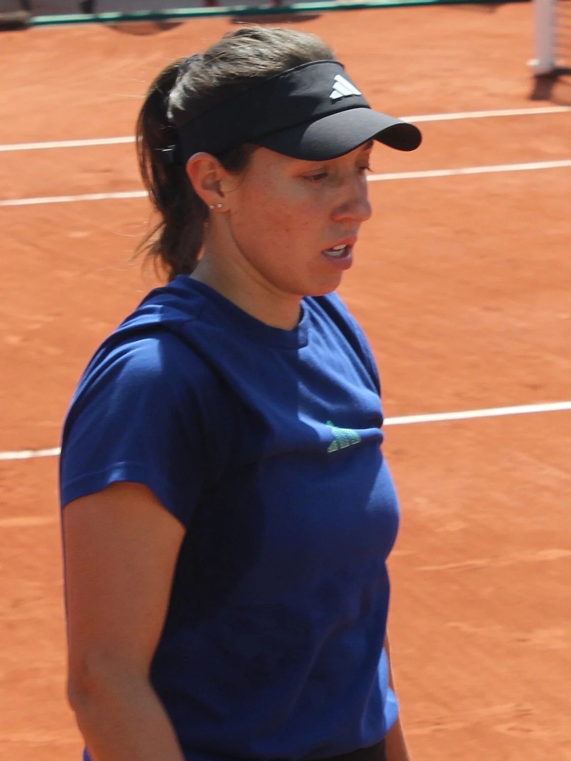 Jessica Pegula con visera en una pista de entrenamiento de tierra batida en Roland Garros