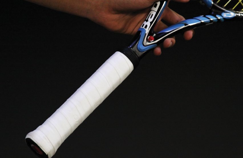 A racquet handle wrapped with an overgrip