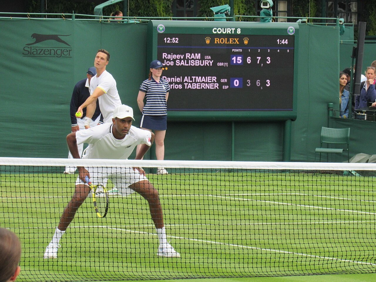 Joe Salisbury serve dietro Rajeev Ram a rete a Wimbledon nel 2022