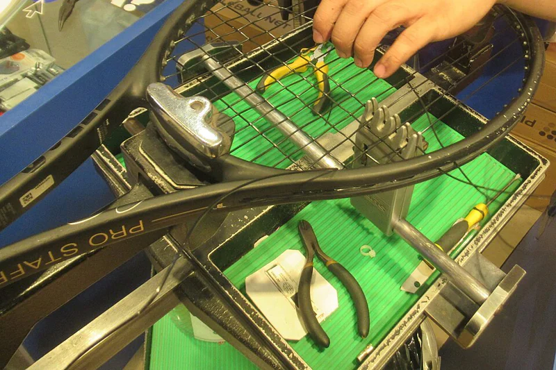 Tennis racquets beside a stringing machine