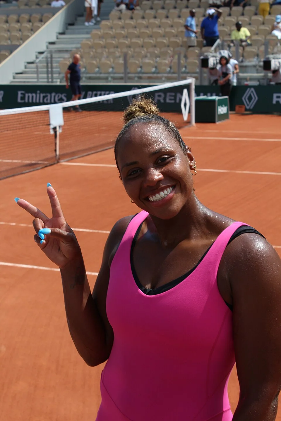 Taylor Townsend lächelt und zeigt auf dem Platz in Roland-Garros 2023 ein V-Zeichen