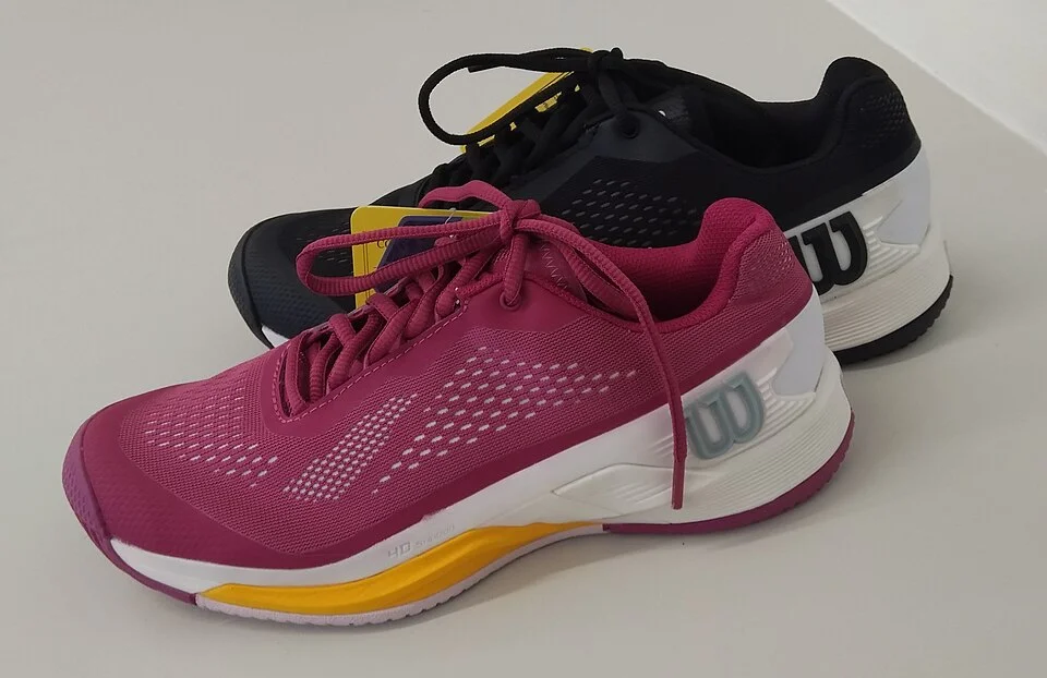 Pink-schwarze Wilson-Rush-Pro-Tennisschuhe vor hellem Hintergrund